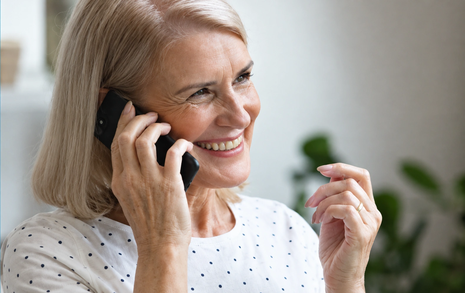 Woman smiling while speaking on a mobile phone